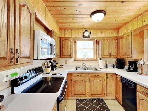 a large kitchen with wooden cabinets and a sink at Cozy Cabin in Oakland