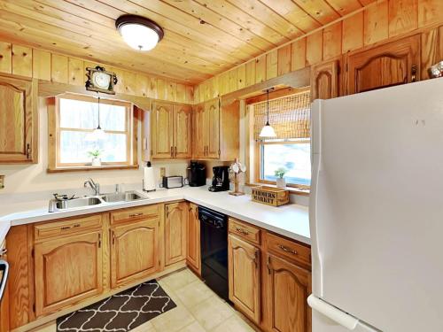 a kitchen with wooden cabinets and a white refrigerator at Cozy Cabin in Oakland