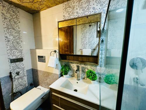 a bathroom with a sink and a mirror and a toilet at Oxygen Inn-Couple Friendly-Noida Sector20 in Noida