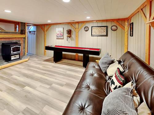 a living room with a leather couch and a piano at Cozy Cabin in Oakland