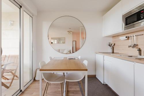 - une cuisine et une salle à manger avec une table et un miroir dans l'établissement Bord de mer, Jardin privé, 100 m de la mer, à Tourgéville