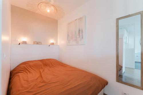 une petite chambre avec un lit et un miroir dans l'établissement Bord de mer, Jardin privé, 100 m de la mer, à Tourgéville