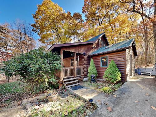 a log cabin with a porch and stairs to it at Cozy Cabin in Oakland