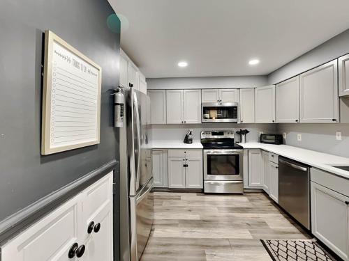 a kitchen with white cabinets and stainless steel appliances at Koi at the Lake in Oakland