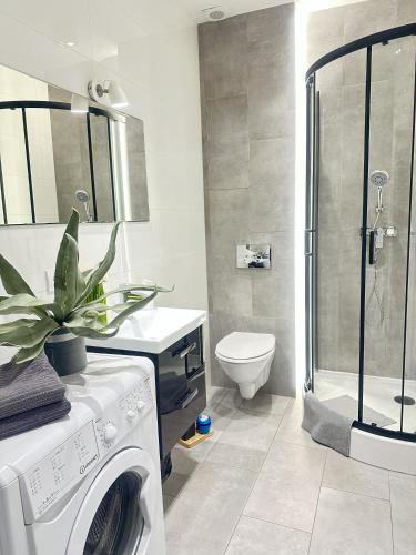 a bathroom with a washing machine and a toilet at Exclusive Apartments Smolna in Warsaw