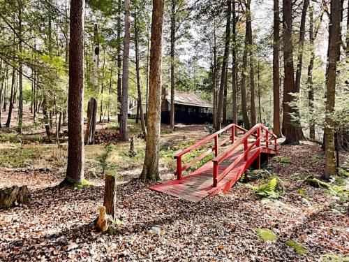 a red bridge in the middle of a forest at Koi at the Lake in Oakland