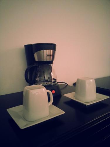 a coffee maker and two cups on a counter at Illa Hotel in Cusco