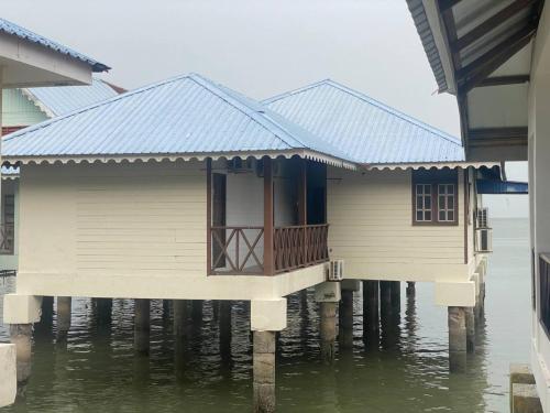 a row of houses on stilts in the water at Capital O 91118 Chalet Seri Idaman in Kampong Batu Maung