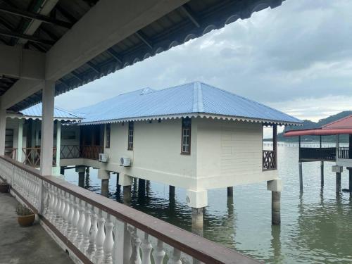 a house on the water next to a dock at Capital O 91118 Chalet Seri Idaman in Kampong Batu Maung