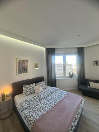 a bedroom with a large bed and a large window at Exclusive Apartments Smolna in Warsaw