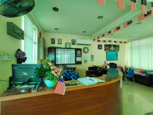 an office with a reception counter with an american flag at Capital O 91118 Chalet Seri Idaman in Kampong Batu Maung