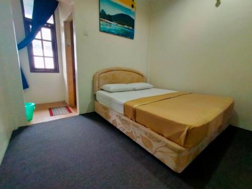 a bedroom with a bed in a room with a window at Capital O 91118 Chalet Seri Idaman in Kampong Batu Maung