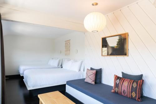 a bedroom with two beds and a bench in a room at Scribner's Catskill Lodge, a Member of Design Hotels in Hunter
