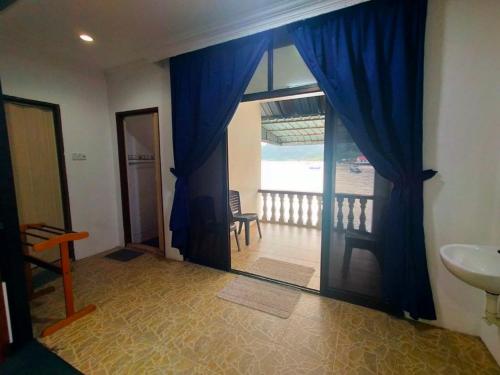 a bathroom with a door to a balcony with a sink at Capital O 91118 Chalet Seri Idaman in Kampong Batu Maung