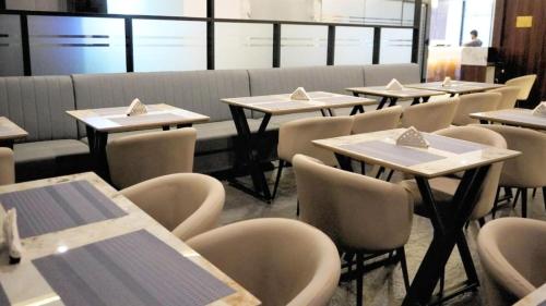 a row of tables and chairs in a restaurant at Elite Hotel Gachibowli in Hyderabad