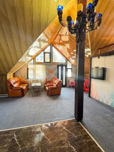 a living room with couches and a tv in a house at Paxlava Dilijan Guesthouse & Restaurant in Dilijan