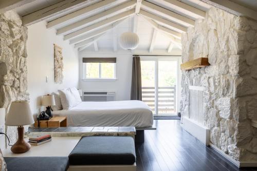 a bedroom with a bed and a stone wall at Scribner's Catskill Lodge, a Member of Design Hotels in Hunter