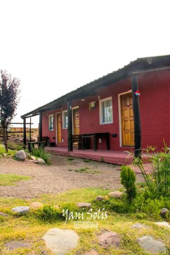 a red house with yellow doors in a yard at Posada Malbec 3 Dormis in Uspallata