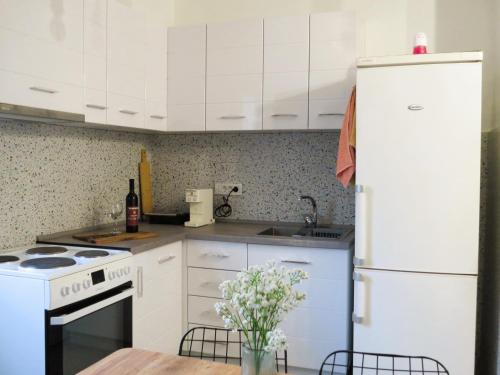 uma cozinha com armários brancos e uma geladeira branca em Duplex 29 em Skopje
