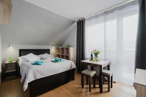 a bedroom with a bed and a table with towels on it at PIONOW Pokoje WaWa - adults only in Krynica Morska