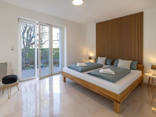 a bedroom with a large bed in a room with windows at Katrin's Place - Wöllstadt Suiten mit Terrasse oder Balkonen in Niederwöllstadt