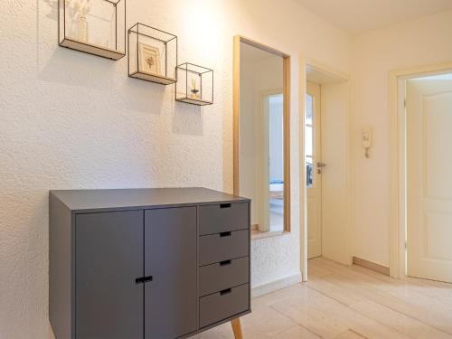 a gray dresser in a room with a wall at Katrin's Place - Wöllstadt Suiten mit Terrasse oder Balkonen in Niederwöllstadt