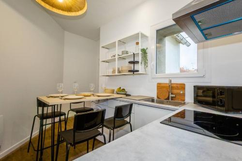 - une cuisine avec un comptoir et des chaises dans l'établissement La Résidence - Louez l'un de nos 4 appartements privés !, à Cholet