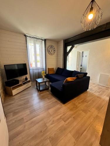 un salon avec un canapé bleu et une télévision dans l'établissement Appart 50M2 - 2 Chambres - Centre-Gare-Mer Plage à pied, à La Bernerie-en-Retz