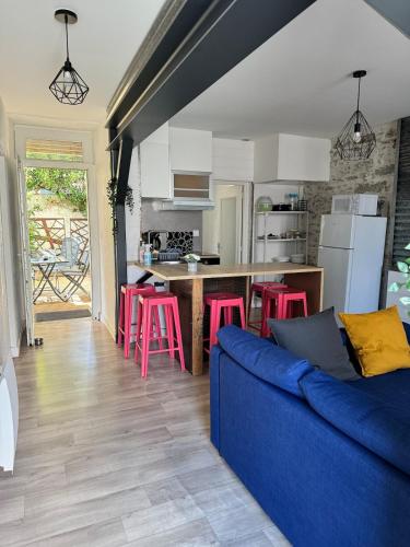 un salon avec un canapé bleu et une cuisine dans l'établissement Appart 50M2 - 2 Chambres - Centre-Gare-Mer Plage à pied, à La Bernerie-en-Retz