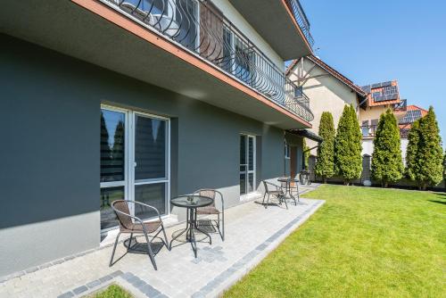 a patio with chairs and a table in a yard at PIONOW Pokoje WaWa - adults only in Krynica Morska