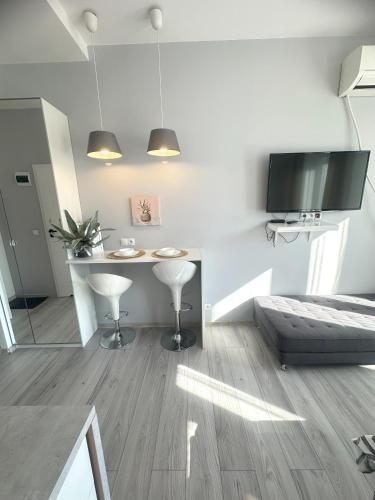 a living room with a table and a tv at Exclusive Apartments Smolna in Warsaw