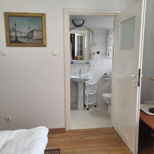 a white bathroom with a sink and a toilet at Pałacyk Srebrna Fala in Międzyzdroje