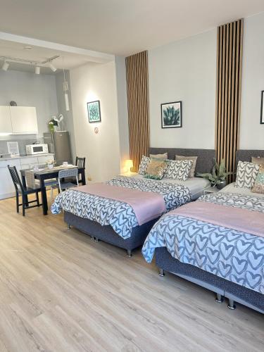 a hotel room with two beds and a dining room at Exclusive Apartments Smolna in Warsaw
