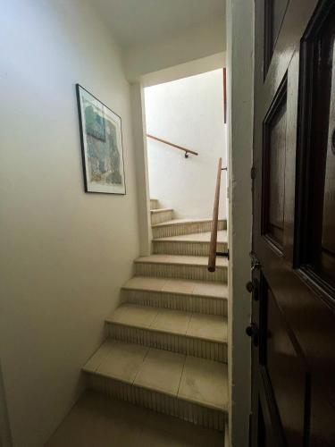 a hallway with stairs with a door and a picture at Villa Petrea in San Juan