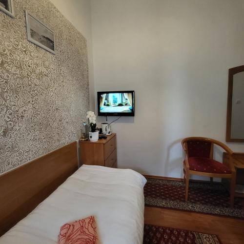 a hotel room with a bed and a tv at Pałacyk Srebrna Fala in Międzyzdroje
