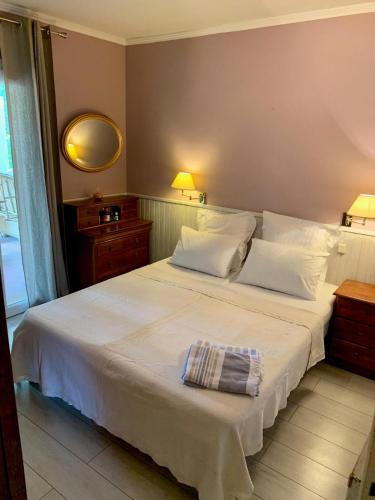 une chambre avec un grand lit blanc avec un miroir dans l'établissement Villa with large spacious apartment, Privatized with big garden and swimming pool, à Beaulieu