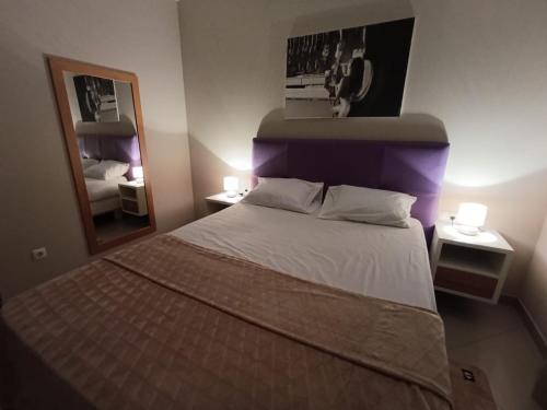 a bedroom with a large bed with a mirror at Elly Apartamentos in Mindelo