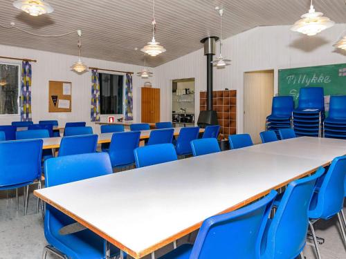 a classroom with rows of tables and blue chairs at Budget Holiday Stay on Læsø Island in Læsø