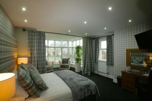 a hotel room with a bed and a television at The Sunningdale in Bamburgh