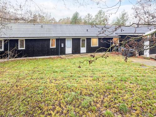a black house with a yard in front of it at 2 person Holiday Home in Læsø in Læsø