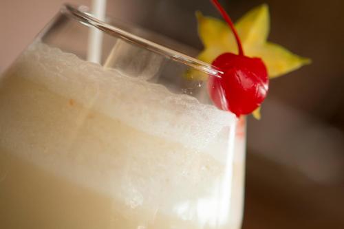a close up of a drink with a cherry on top at Rincon del Valle Hotel & Suites in San José
