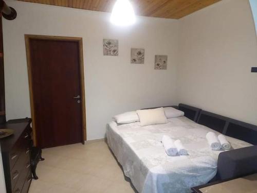 a bedroom with a bed with white sheets and pillows at Messonghi- La Pazzeli in Káto Spílaion