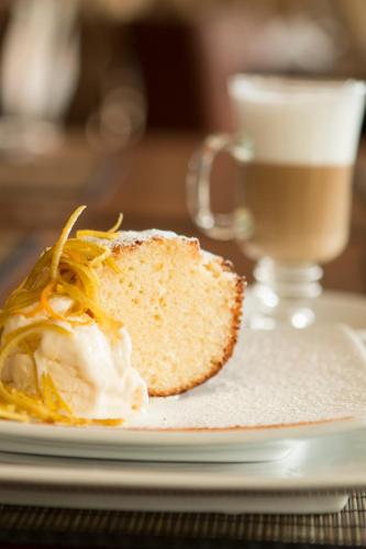 a piece of bread on a plate with a cup of coffee at Rincon del Valle Hotel & Suites in San José