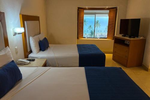 Una habitación de hotel con dos camas y un televisor. en Spectacular view & private terrace!, en Puerto Vallarta