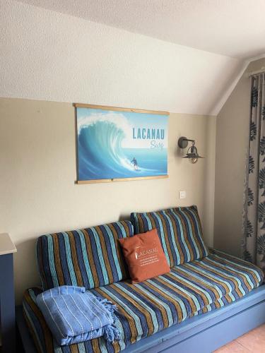 - un canapé dans le salon orné d'une peinture à vagues dans l'établissement Résidence Lacanau Les Pins - maeva Home - Appartement 2 Pièces 5 Personnes - Sélection MAE-1034, à Lacanau