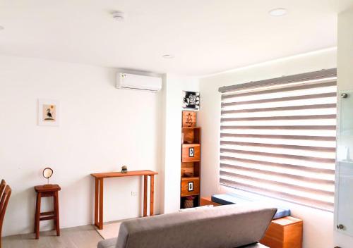 a living room with a couch and a window at Coral Apartments in Puerto Ayora