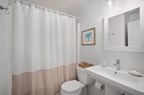 a white bathroom with a toilet and a sink at Ocean Front Condo with Private Water Front Balcony in Hilton Head Island