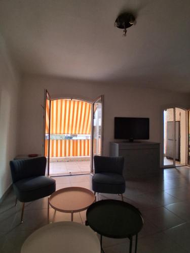 un salon avec deux chaises et une télévision dans l'établissement Studio ST CYR SUR MER, aux Lecques