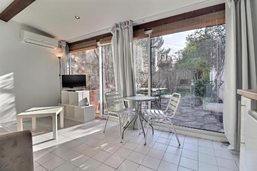 a dining room with a table and chairs and a large window at Studio à Allauch in Allauch