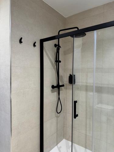 una ducha con puerta de cristal en un baño en Anais Apartments by gaiarooms, en Barcelona